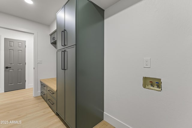 interior space with light wood finished floors, baseboards, and light countertops