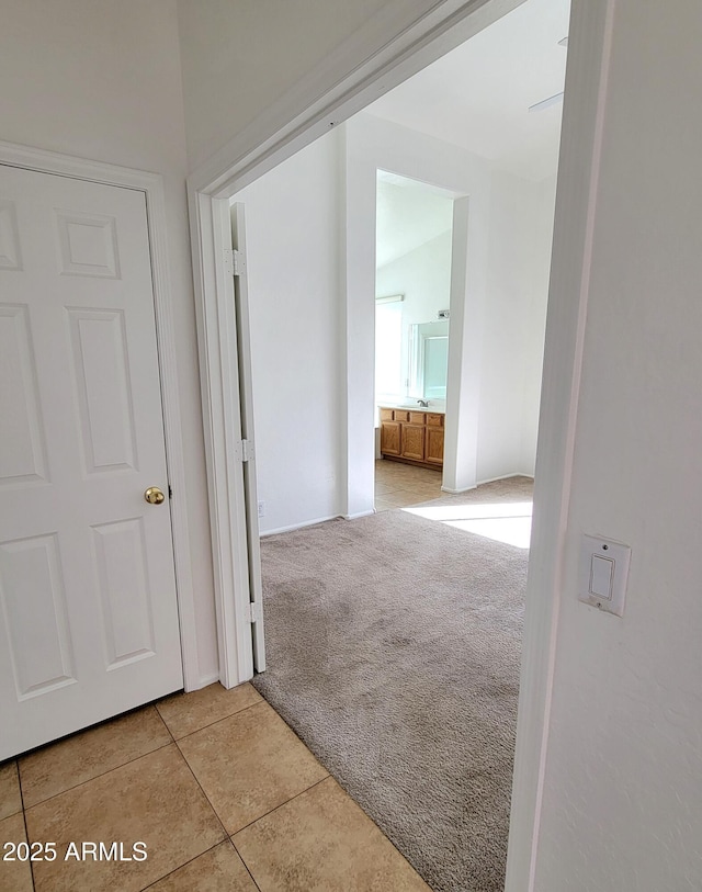 hall featuring tile patterned flooring and carpet flooring