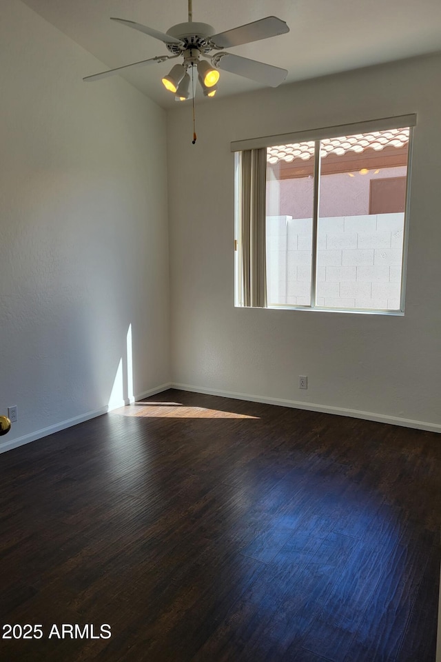 spare room with ceiling fan, wood finished floors, and baseboards