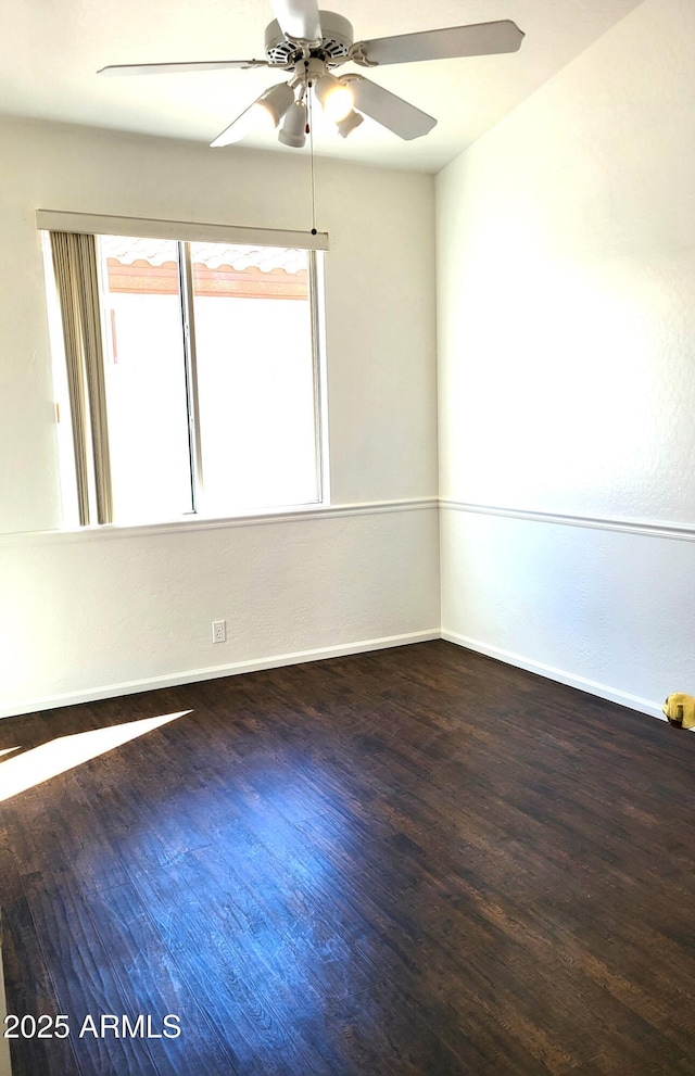 spare room featuring a ceiling fan, baseboards, and wood finished floors