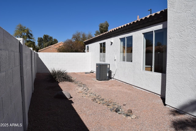 view of yard with central AC unit and a fenced backyard