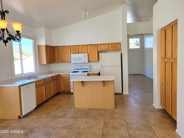 kitchen with light countertops, a kitchen island, a sink, a chandelier, and white appliances