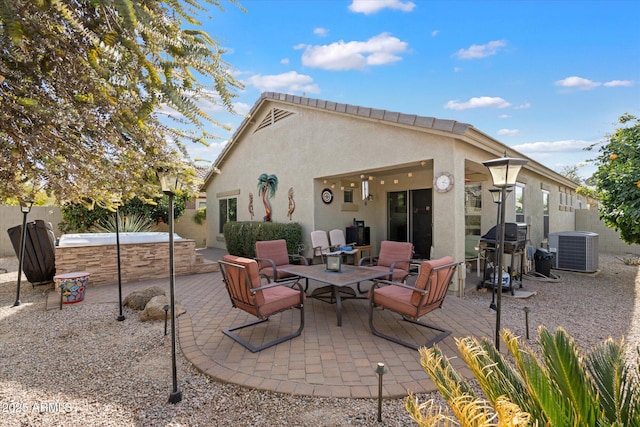 back of house with central AC, a hot tub, and a patio area