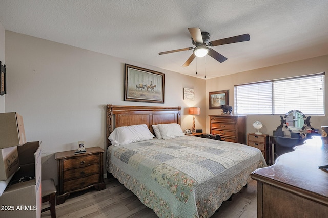 bedroom featuring ceiling fan, dark wood-type flooring, and a textured ceiling