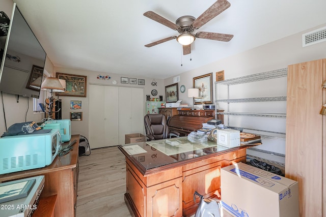 home office with ceiling fan and light hardwood / wood-style flooring