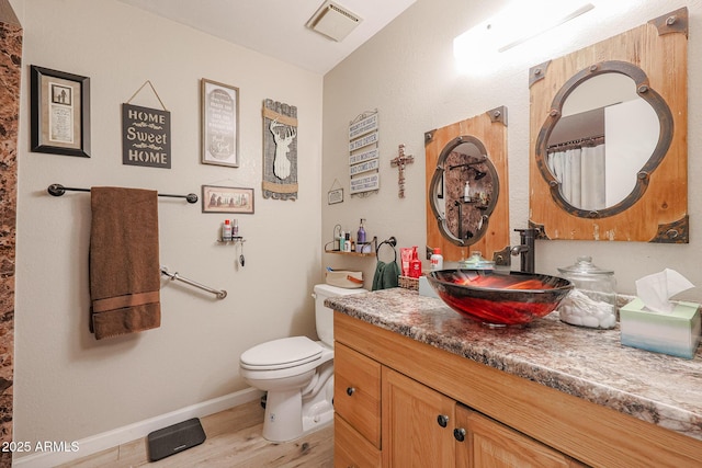 bathroom featuring toilet, vanity, and hardwood / wood-style flooring