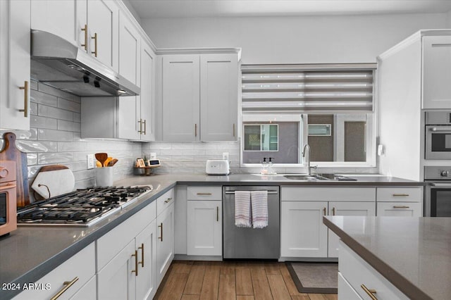 kitchen featuring hardwood / wood-style floors, appliances with stainless steel finishes, sink, and white cabinetry