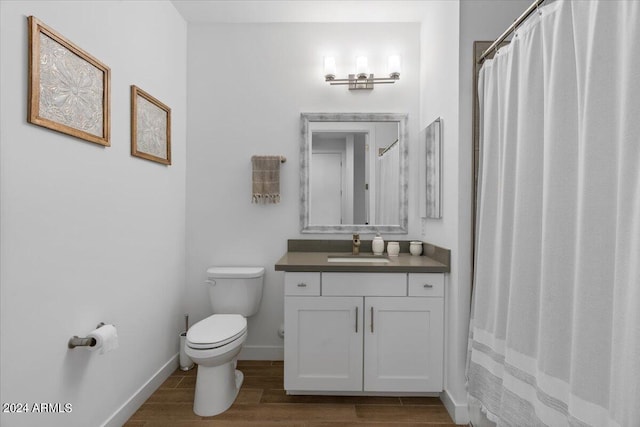 bathroom featuring wood-type flooring, vanity, and toilet