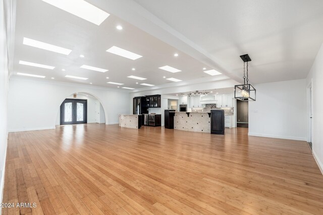 unfurnished living room featuring french doors and light wood-type flooring