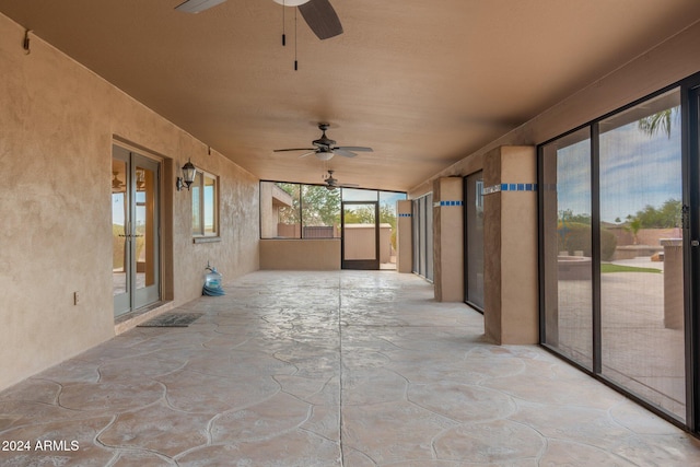 unfurnished sunroom featuring ceiling fan