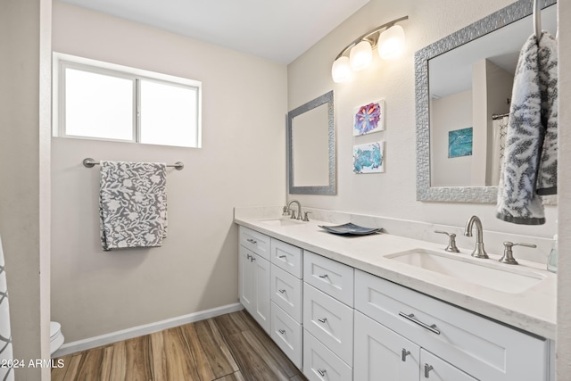 bathroom featuring vanity, wood-type flooring, and toilet