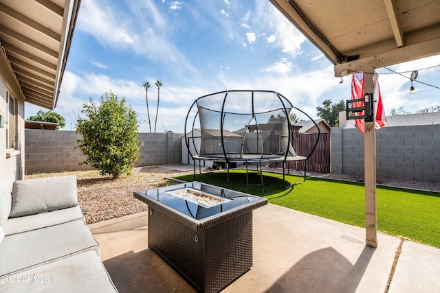 view of patio / terrace featuring a trampoline and an outdoor fire pit