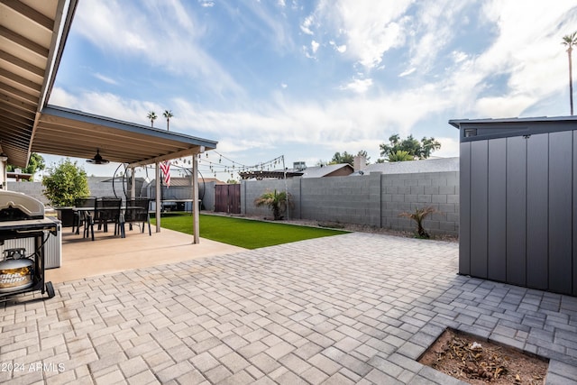 view of patio / terrace with a grill and a storage shed