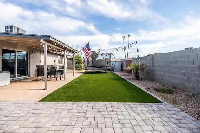 view of yard with a patio area, a shed, and a trampoline