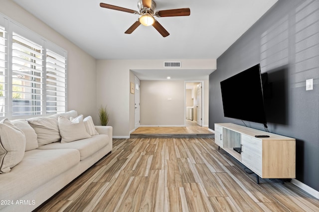 living room featuring light hardwood / wood-style flooring and ceiling fan