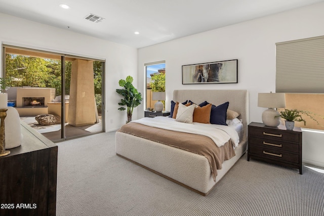 8227 E Beardsley Rd, Scottsdale, AZ 85255 - carpeted bedroom with recessed lighting, access to outside, visible vents, and a warm lit fireplace
