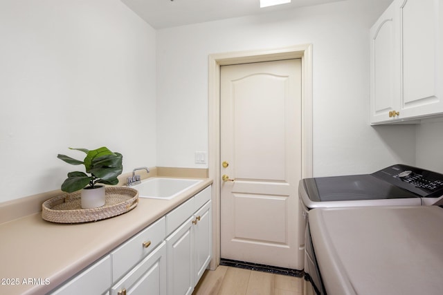 8227 E Beardsley Rd, Scottsdale, AZ 85255 - washroom with light wood-style floors, washing machine and clothes dryer, a sink, and cabinet space