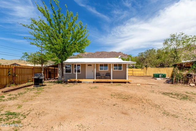 rear view of property with a fenced backyard and a deck