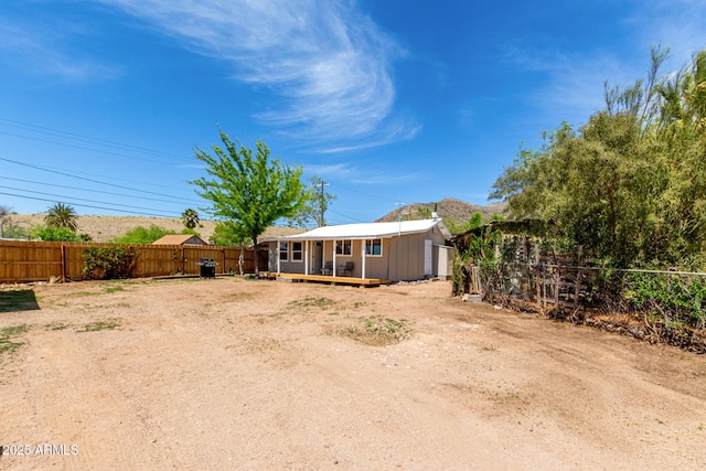 back of house with a fenced backyard and a deck