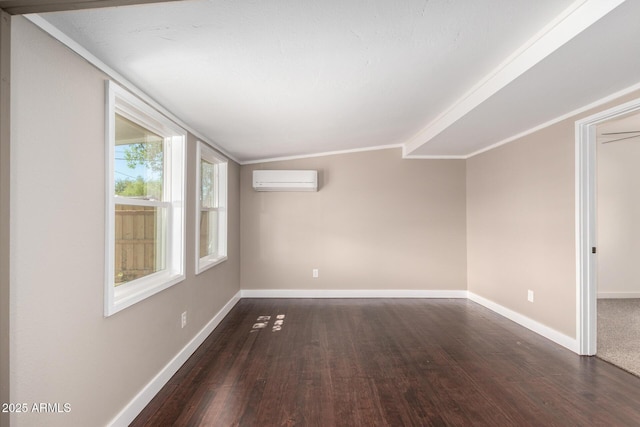 empty room featuring wood finished floors, crown molding, baseboards, and an AC wall unit