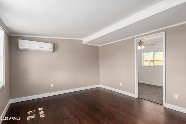 empty room with baseboards, wood finished floors, a wall unit AC, and ceiling fan