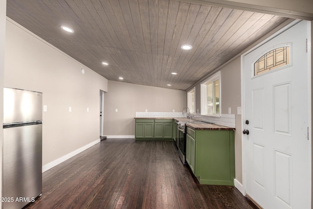 kitchen featuring a sink, green cabinetry, freestanding refrigerator, dark wood-style flooring, and recessed lighting