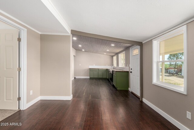 kitchen featuring recessed lighting, baseboards, green cabinetry, and dark wood-style floors