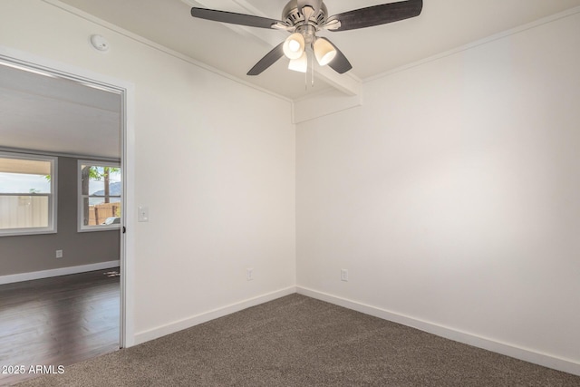 spare room featuring dark carpet, baseboards, a ceiling fan, and crown molding