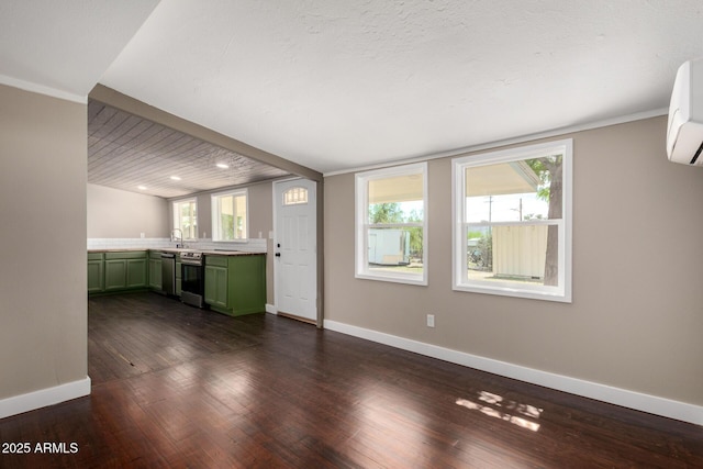 unfurnished living room with a wall mounted AC, baseboards, a sink, and dark wood-style floors