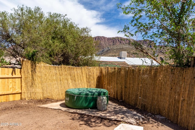 view of yard with a fenced backyard and a mountain view
