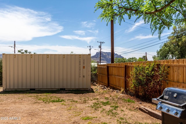 view of yard featuring fence and a mountain view