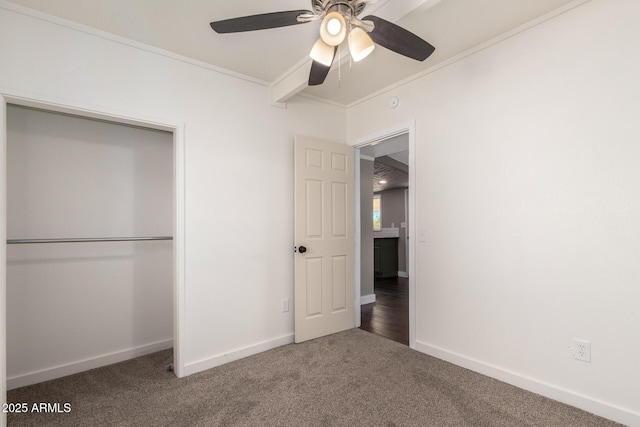 unfurnished bedroom with carpet, ornamental molding, a closet, baseboards, and ceiling fan