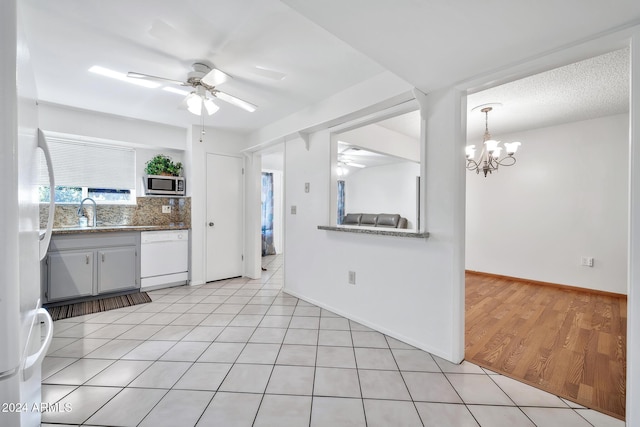 kitchen with white dishwasher, ceiling fan with notable chandelier, sink, a textured ceiling, and light hardwood / wood-style floors