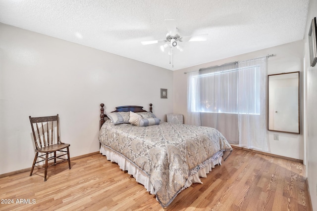 bedroom featuring ceiling fan, hardwood / wood-style floors, and a textured ceiling