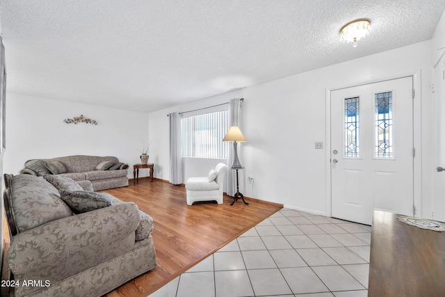 living room with light hardwood / wood-style floors and a textured ceiling