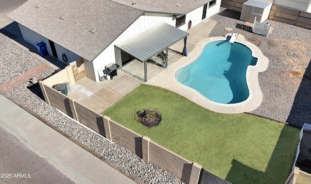 view of swimming pool featuring a patio and a lawn