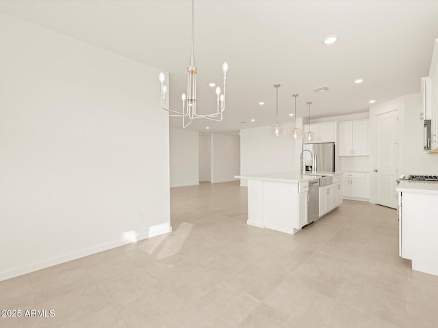 kitchen featuring a kitchen island with sink, hanging light fixtures, white cabinets, and appliances with stainless steel finishes