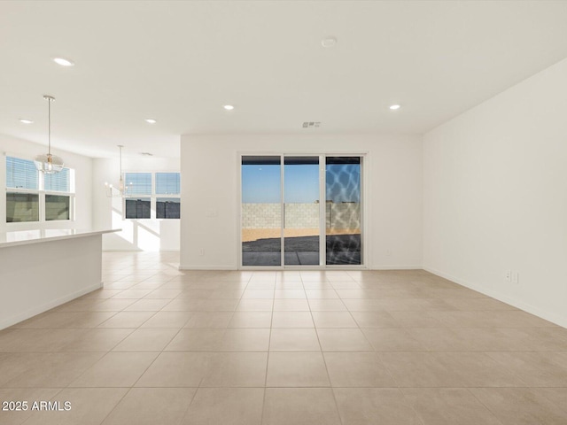 spare room with light tile patterned flooring and a notable chandelier