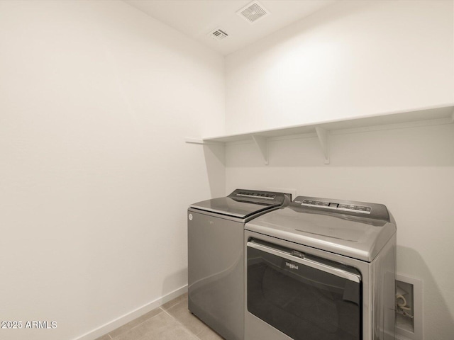 laundry room featuring washer and dryer and light tile patterned floors