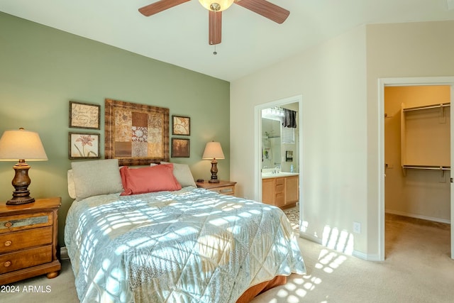 carpeted bedroom with ceiling fan, a walk in closet, a closet, and connected bathroom