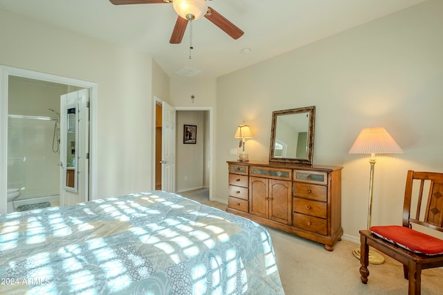 bedroom with connected bathroom, light carpet, and ceiling fan