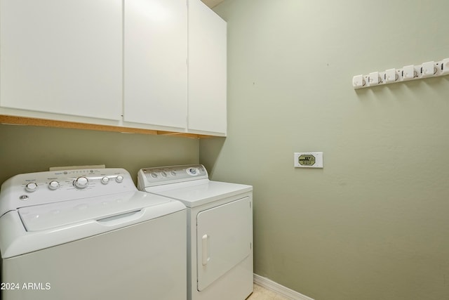 washroom with washer and dryer and cabinets