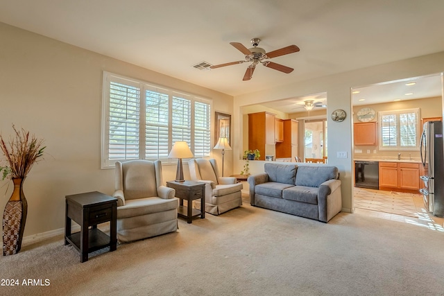 living room with ceiling fan, light colored carpet, and sink