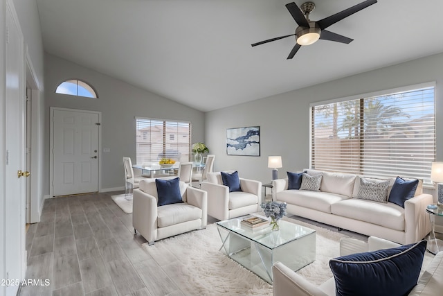 living room featuring a ceiling fan, light wood-style floors, lofted ceiling, and plenty of natural light