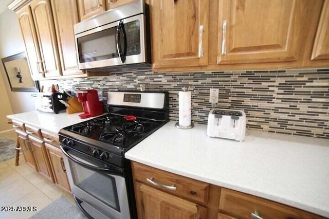 6731 S 37th Dr, Phoenix, AZ 85041 - kitchen with stainless steel appliances, light countertops, backsplash, and light tile patterned flooring