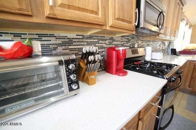 6731 S 37th Dr, Phoenix, AZ 85041 - kitchen featuring appliances with stainless steel finishes, tasteful backsplash, light countertops, and brown cabinets