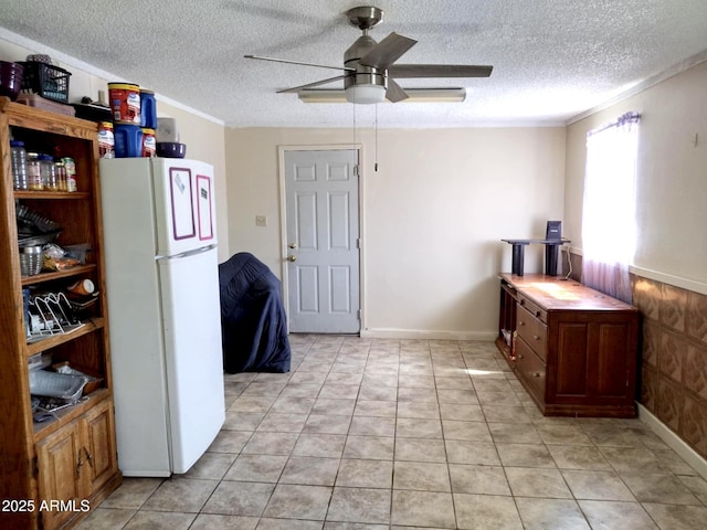 111 W 9th St, Ajo, AZ 85321 - kitchen with freestanding refrigerator, ceiling fan, a textured ceiling, ornamental molding, and light tile patterned floors