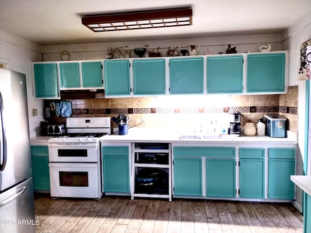 111 W 9th St, Ajo, AZ 85321 - kitchen with freestanding refrigerator, range with two ovens, a sink, tasteful backsplash, and light countertops