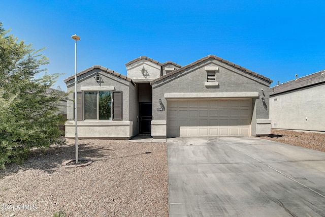 view of front of house featuring a tile roof, an attached garage, driveway, and stucco siding