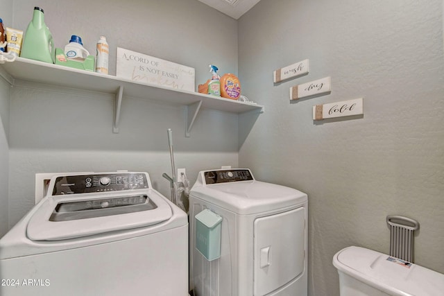 washroom featuring laundry area, independent washer and dryer, and a textured wall